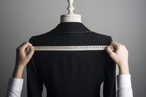 Woman Measuring Jacket on Male Dress Form